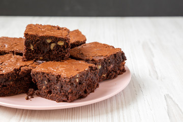 Homemade chocolate brownies on a pink plate, low angle view. Close-up. Copy space.