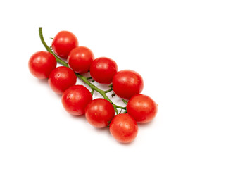 A branch of red cherry tomatoes on a white background. Small and juicy vegetable is rich in vitamins and trace elements. Healthy food. Fresh and organic vegetables. Raw food