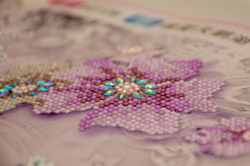 Diamond painting embroidery craft.  Acrylic rhinestones. Closeup, selective focus