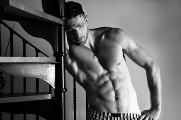 Portrait of handsome topless man with sixpack looking at camera