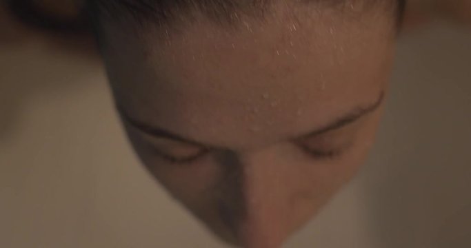 Spa woman showering relaxing standing under running water in hot cold shower. Handsome girl doing wellness treatments improve health immunity enjoy her skin expose face to water stream