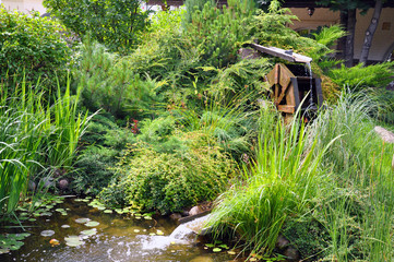 Driving mill wheel with falling water in the garden.
