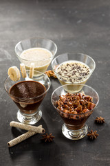 Set of chocolate, coffee and Vanilla pudding in a glass on black background