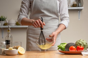 Cooking. The chef makes the sauce, whipping it, in the process of vegetarian salad in the home kitchen. Light background. Restaurant menu, menu, recipe book. Healthy nutrition, detox