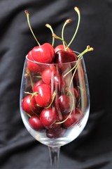 fresh cherries in a glass on a black background