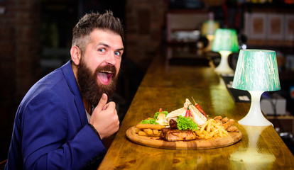 Enjoy meal. High calorie snack. Relax after hard working day. Businessman formal suit sit at bar...