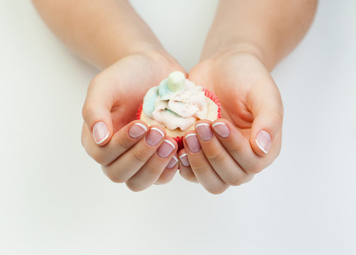 Woman's hands with french manicure nails holding sweet puncake