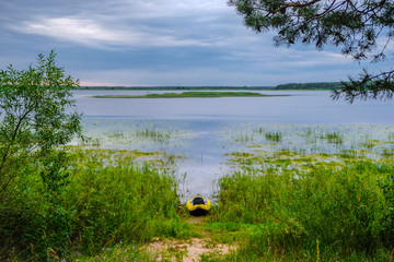 Yellow empty kayak on the swampy shore of Lake Lyubyaz in Ukraine. Water tourism. Ukrainian nature....