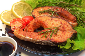 Grilled Salmon Steaks on a Plate with Lemon and Tomato