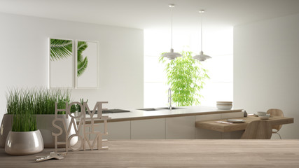 Wooden table, desk or shelf with potted grass plant, house keys and 3D letters making the words home sweet home, over modern white kitchen, interior design, blur background