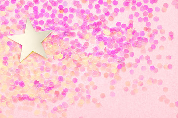 Confetti and silver stars on a pink background, festive concept.