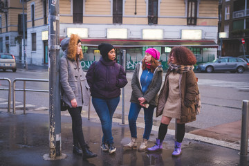 group of young women standing in the street and talking