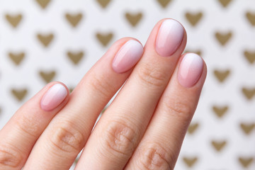 Hand with manicure at the creative background with hearts. © Darya Lavinskaya