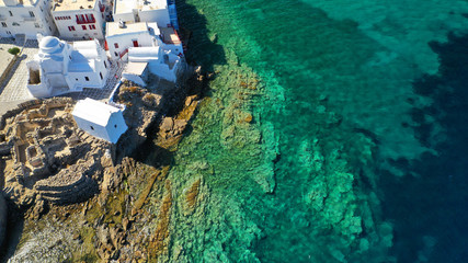 Fototapeta na wymiar Aerial drone photo of popular landmark chapel of Paraportiani with beautiful emerald colour rocky seascape next to little Venice, main town of Mykonos island, Cyclades, Greece