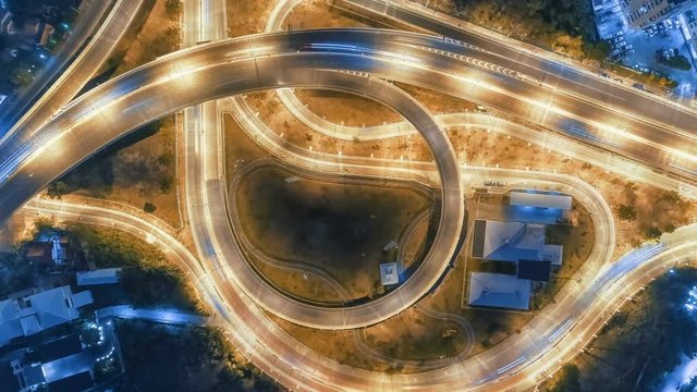 Hyperlapse timelapse of night city traffic on 4-way stop street intersection circle roundabout in bangkok at night, thailand. 4K UHD horizontal aerial view.