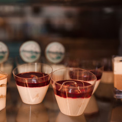 Small cakes with fruits close up in show window.