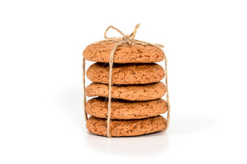 Homemade cookies. Five sweet cookie made from oatmeal flour, stacked and tied with linen rope in rustic style. Tasty biscuit in high resolution closeup isolated on white background. Homemade bakery.
