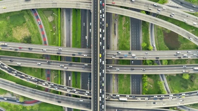 timelapse of night city traffic on 4-way stop street intersection circle roundabout in bangkok, thailand. 4K UHD horizontal aerial view.Zoom out.
