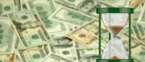 image of hourglass on money background close up