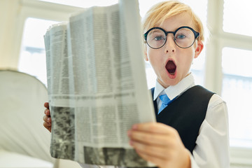 Young boy astonished while reading