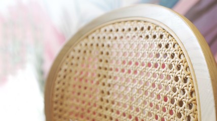 a detail of wooden chair backrest that made of natural colored rattan and solid wood frame by...