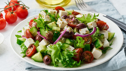Greek Salad with feta and tomatoes, dieting food on white background closeup