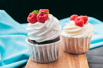 Close up of some decadent gourmet cupcakes frosted with a variety of frosting flavors