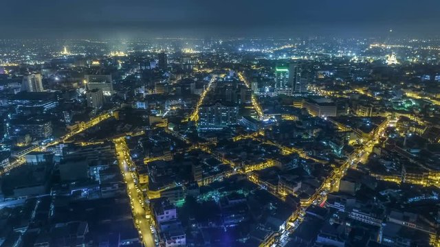 Hyperlapse timelapse of night city traffic on 4-way stop street intersection circle roundabout in bangkok at night, thailand. 4K UHD horizontal aerial view.