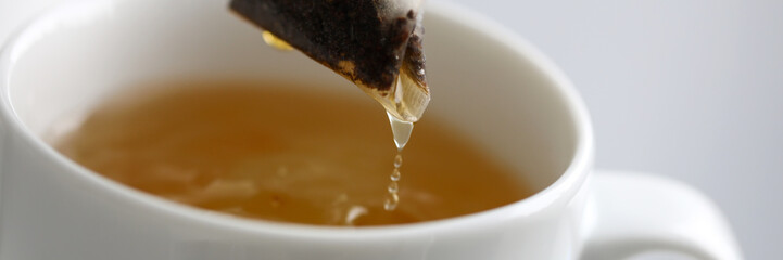 Hot water trickling down from herbal potion teabag