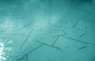 Cracked paint texture in cyan color.