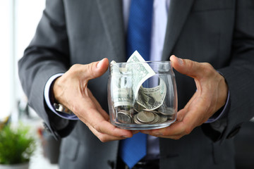 Rich man holding jar with bib amount of US dollars