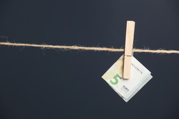 Billetes de euro, colgados de una cuerda sujetos por pinzas de madera de extender la ropa