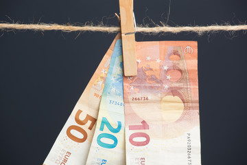 Billetes de Euro colgadois de una cuerda y cogidos por pinzas de madera de extender la ropa