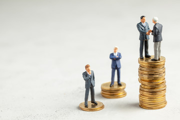 Businessmen shake hands as a symbol of a successful profitable transaction. Businessmen on a stack of gold coins as a symbol of success or successful investments. Copy space for text.