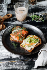 Smoked Salmon and Veggies Toasts for Breakfast on a Dark Wooden Background