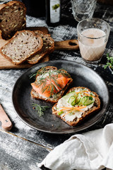 Smoked Salmon and Veggies Toasts for Breakfast on a Dark Wooden Background