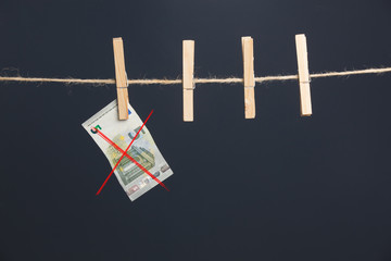 Dinero, billetes de Euro colgados por pinzas en una cuerda como si fueran ropa estendida para ser secada. Dinero es la materia prima de la sociedad capitalista, Los bancos, los negocios, las empresas 