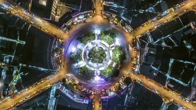aerial top view traffic circle road roundabout multi 6 lanes in bangkok city at night, Time lapse top road in thailand, zoom in.