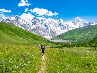 Fototapeta na wymiar Tourist with a backpack in Caucasus mountains. Svaneti region, Georgia