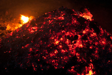 fire on black background. A bunch of burning coals with flashes of fire at night