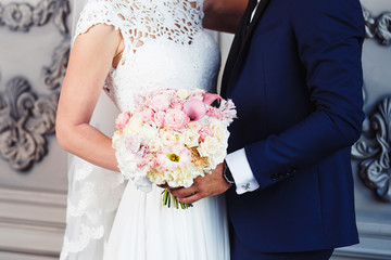 Wedding bouquet in the hands of the bride and groom