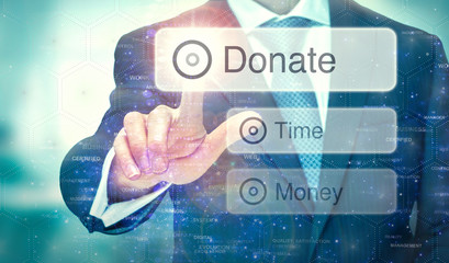 A businessman selecting a button on a futuristic display with a Donate concept written on it.