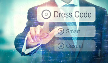 A businessman selecting a button on a futuristic display with a Dress Code concept written on it.