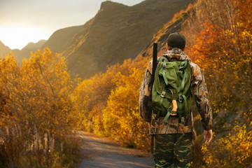 Hunter with a backpack and a gun
