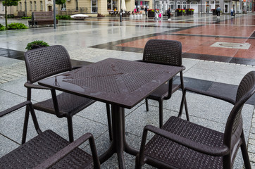 A CITY IN THE RAIN - Wet tables and cafe chairs on the town hall square