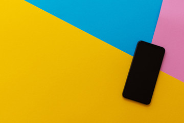 New modern black phone on colorful background, flat lay, copy space