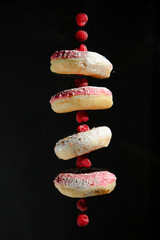 Raspberry and donut on a dark background like skewers