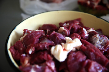 Close up view of fresh finely chopped meat cubes. Red meat small steaks with whitish meat fat.