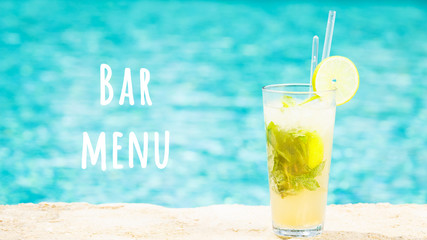 Mojito cocktail at the edge of a resort pool. Concept of luxury vacation. Outdoor pool background....