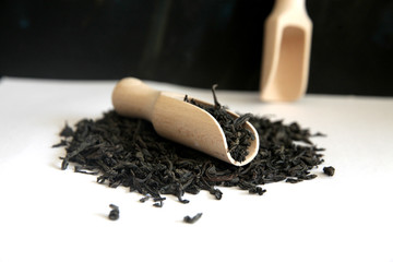 Wooden scoop with dry  black tea leaves